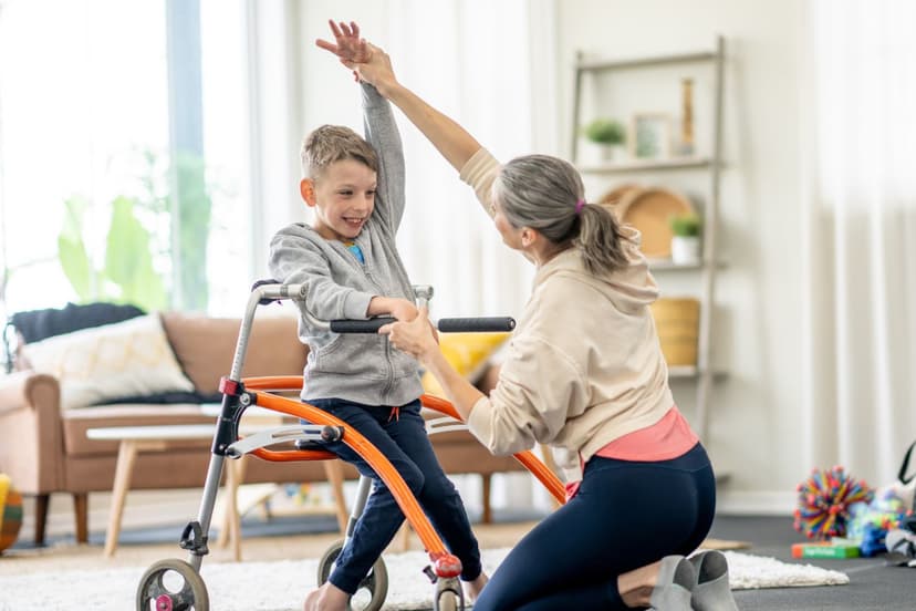 An physical therapist helping a little boy use his walker